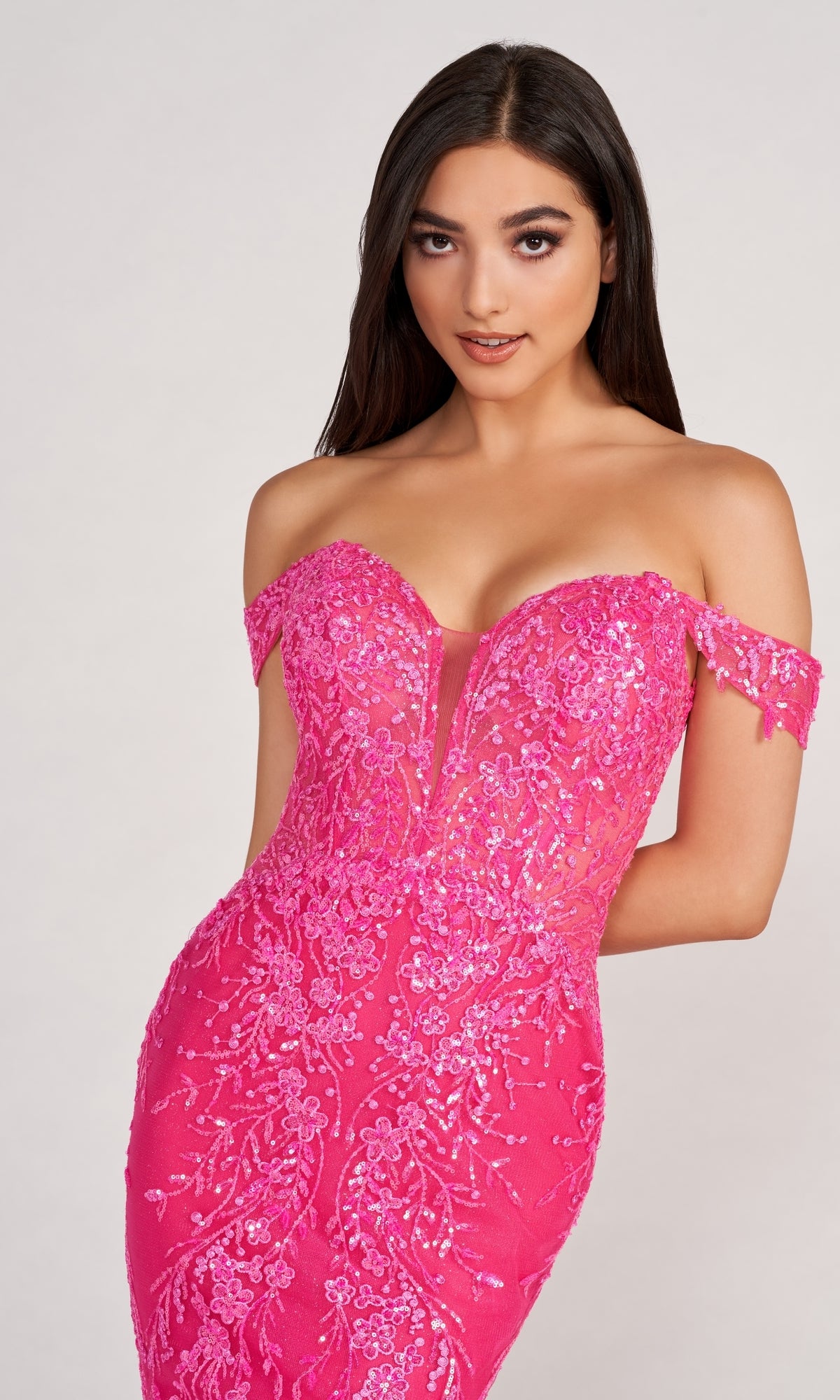 Model wears the Lace-Embroidered Off-Shoulder Long Mermaid Gown, featuring sequin floral patterns and a bright pink hue, while posing against a plain light background.